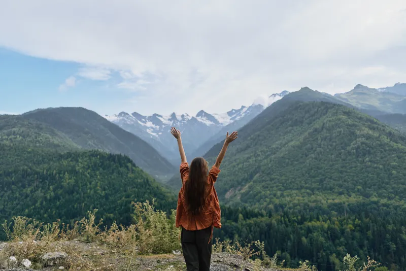 woman mountains nature outdoors freedom hiking authenticity inclusivity arms raised celebrate