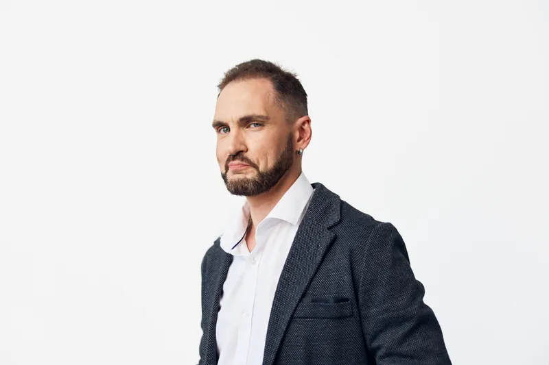 A professional business man stands against a clean isolated white background, conveying confidence and focus. He wears a navy blazer and white shirt, signaling readiness, integrity, and commitment in
