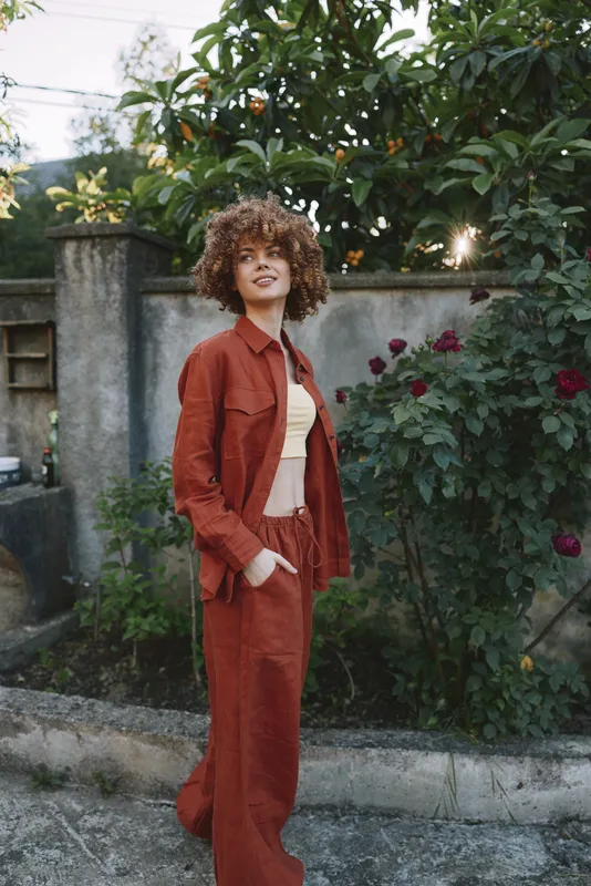 woman lifestyle fashion outdoor portrait confident stylish garden clothing model stands in a sunlit yard, a candid, natural pose showcasing contemporary style