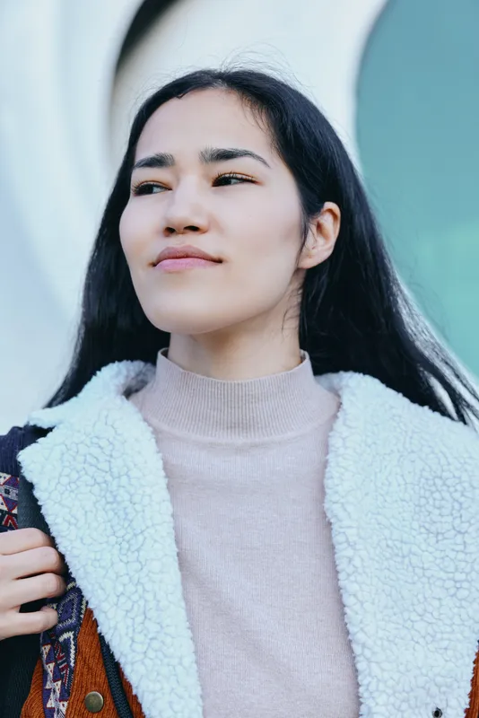 Woman wearing a coat and outerwear in a fashionable outdoors street scene, casual confidence with a sweater knitwear look, urban vibe and chic wardrobe for contemporary style