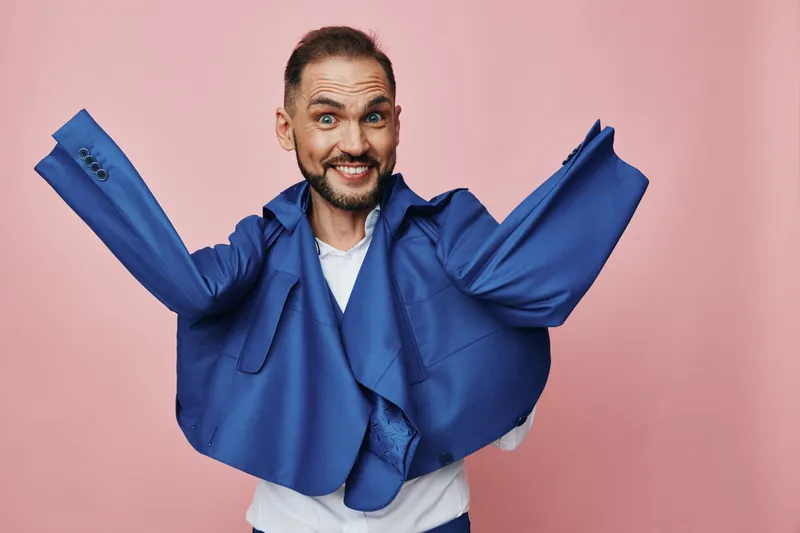 Professional man exudes energy against a pink background, showcasing an isolated color scene. His cheerful expression conveys confidence, enthusiasm, and a dynamic business vibe.
