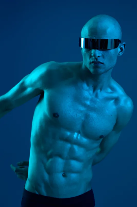 Athletic man with sunglasses in a futuristic setting, showcasing a fit physique and dynamic pose, reflecting modern style and technology.