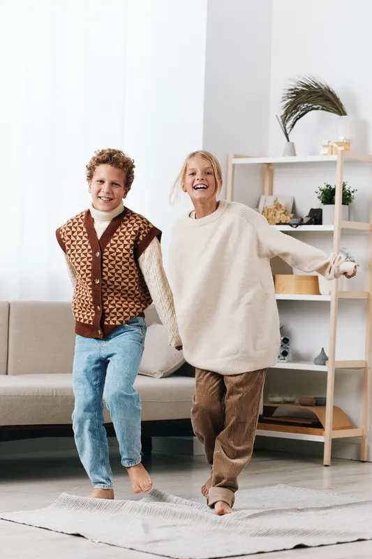 Authentic moment of playful interaction in a cozy home. A child and adult share joyful play, reflecting school spirit, lifestyle warmth, and genuine connection.