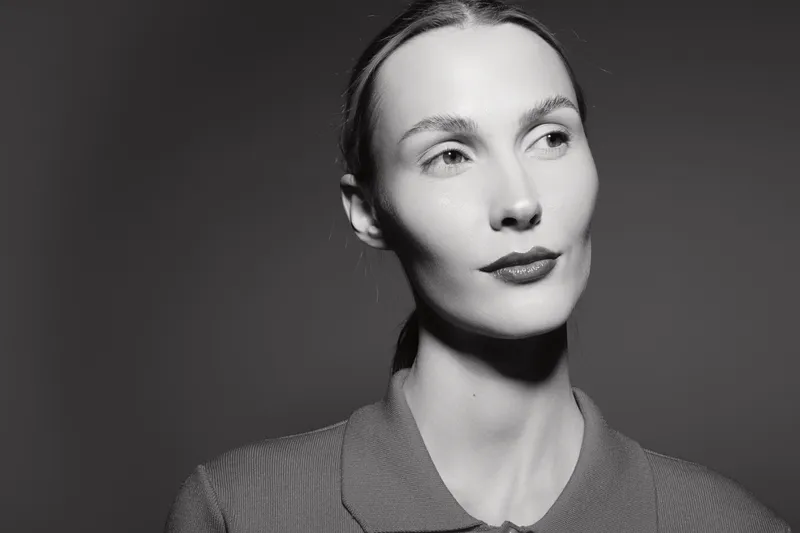 Portrait of a young white woman with pale skin and slicked back hair in monochrome. Concept of elegance, minimalism, and classic beauty.