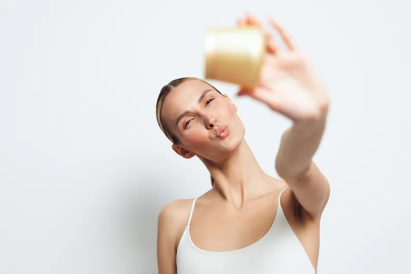 Woman stretching yoga pose, indoor portrait of calm athletic woman, hand raised creating elegant silhouette, soft light on blank background, relaxed breathing moment today