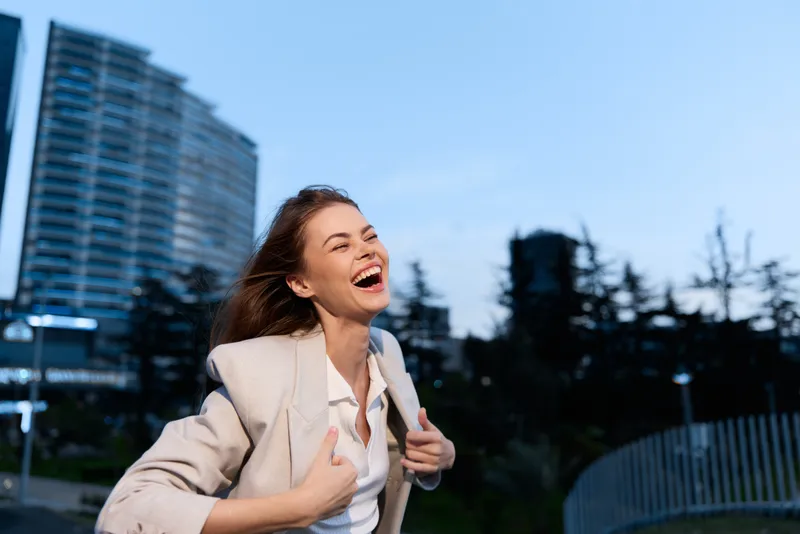 cheerful woman enjoying freedom outdoors in city environment happy joyful expression smiling female professional