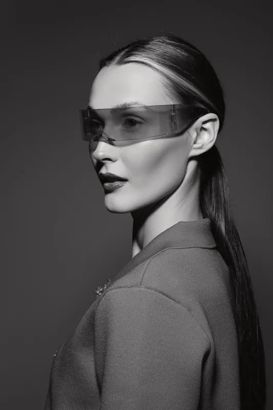 Portrait of a pale white woman with sleek hair and futuristic glasses in studio lighting. Concept for fashion, beauty, and modern style.