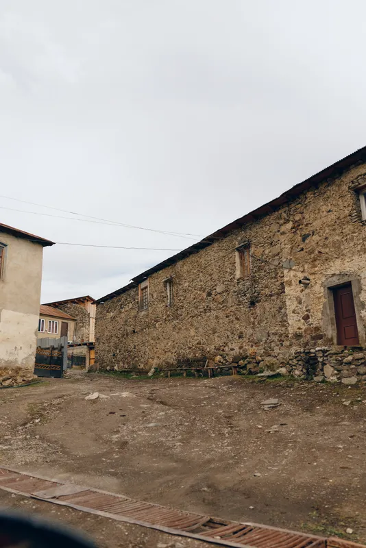 stone, building, rustic, courtyard, village, wall, authenticity, inclusivity, weathered stone houses and empty dirt yard under gray sky