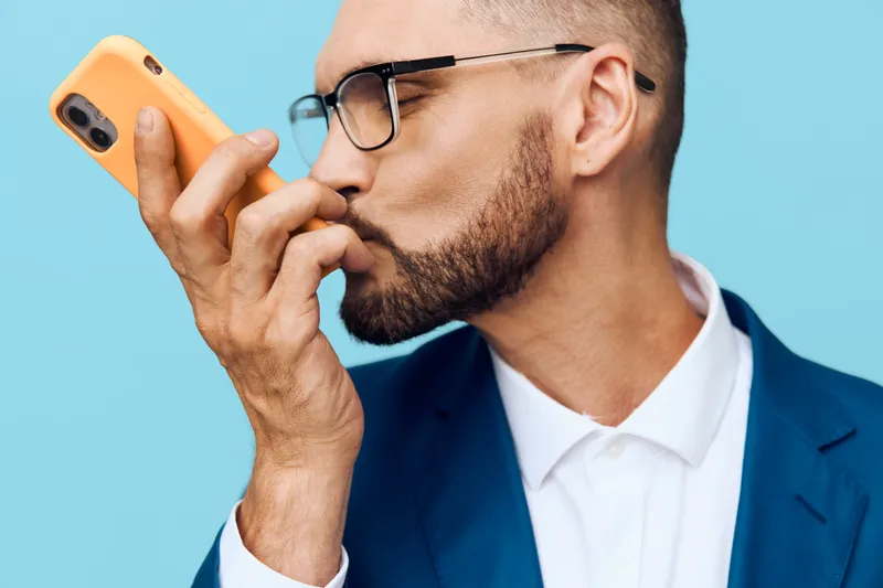 A focused business professional man on a vibrant colored background, isolated setting, shows confident emotion. He wears a sleek suit and glasses, with a thoughtful, determined expression, signaling