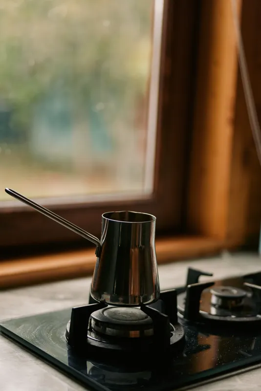 Coffee pot on gas stovetop by window