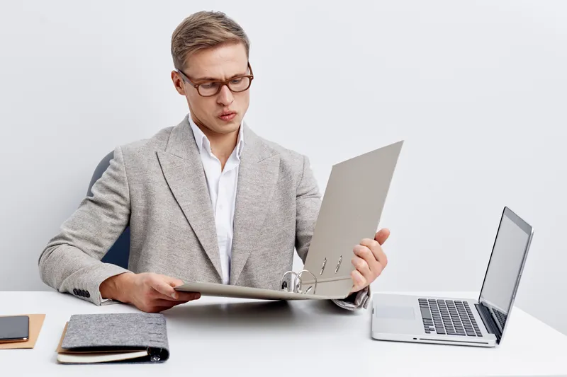 young man working digital nomad browsing open folder laptop smartphone modern office white background business concept