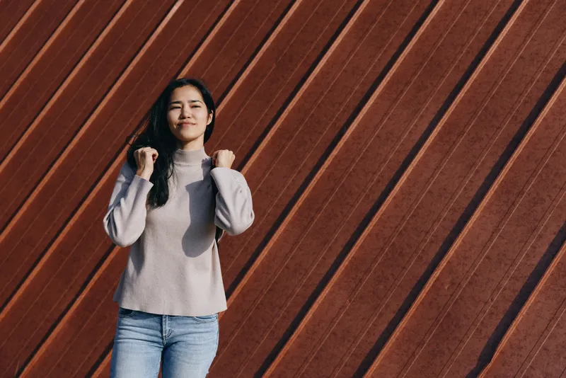 Casual sweater wear, confident pose against diagonal wooden wall, lifestyle fashion shoot showcasing relaxed style, everyday chic and neutral tones in natural light