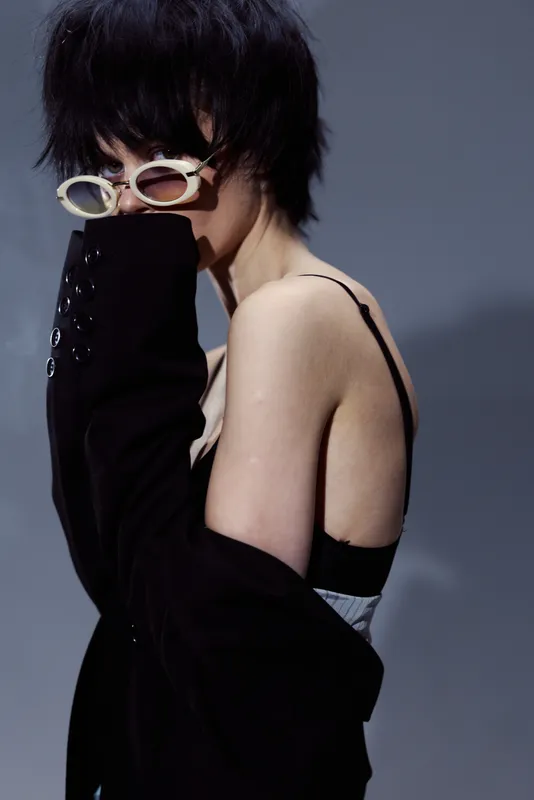 mysterious woman wearing black fashion outfit and sunglasses with short dark hair