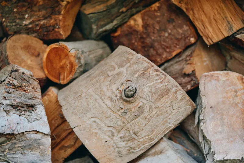 Firewood logs woodpile bark cut wood rustic closeup of stacked seasoned firewood for fireplace, natural textures, outdoor backyard storage, cozy cabin fuel and timber.