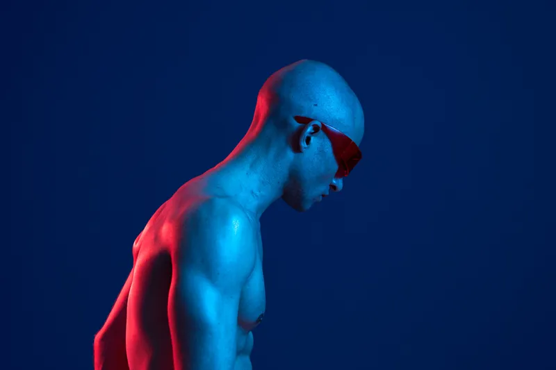 Stylish man in sunglasses, showcasing a modern and artistic atmosphere, highlighted by vibrant lighting. The image combines emotion with a striking visual appeal.