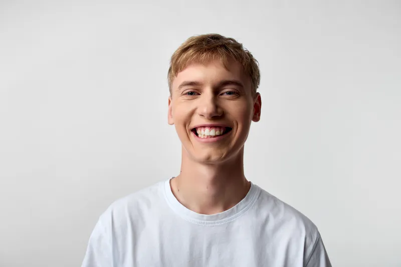 Smiling man in a white t shirt creates a bright, approachable image suitable for lifestyle wellness and personal growth, emphasizing positivity and friendly communication.