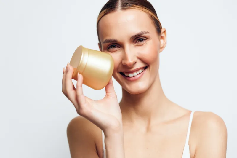 woman smiling holding mug for drink, hydration and morning wellness, spa beauty concept, clean skin skincare routine, young adult woman on white background, relaxing