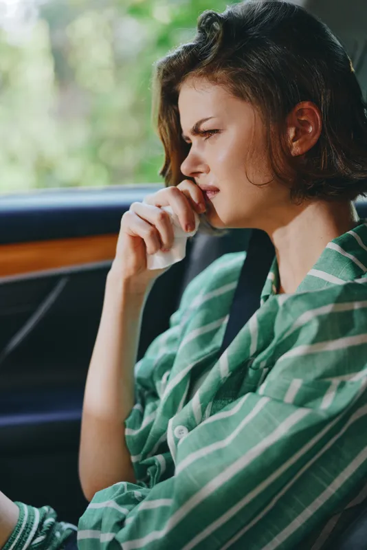 Car, driver, woman, thoughtful pose inside a car as a woman rests her chin on her hand, calm mood, window light highlighting features, suggesting reflection and anticipation before a journey