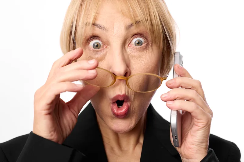 woman surprise shocked business portrait glasses holding telephone blonde studio, wide eyed expression, open mouth, studio light, white background, close up