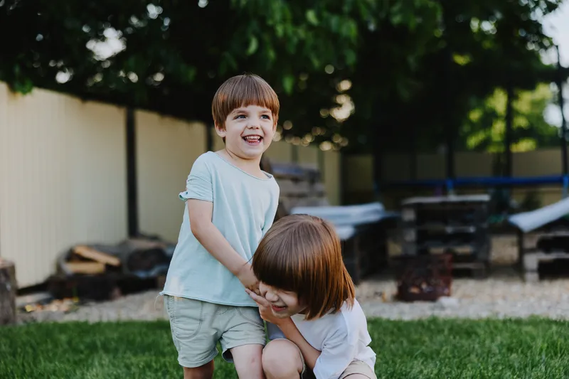 Happy children playing outdoors in a sunny garden, enjoying their time together. Their joyful expressions capture the essence of childhood bliss and innocence.
