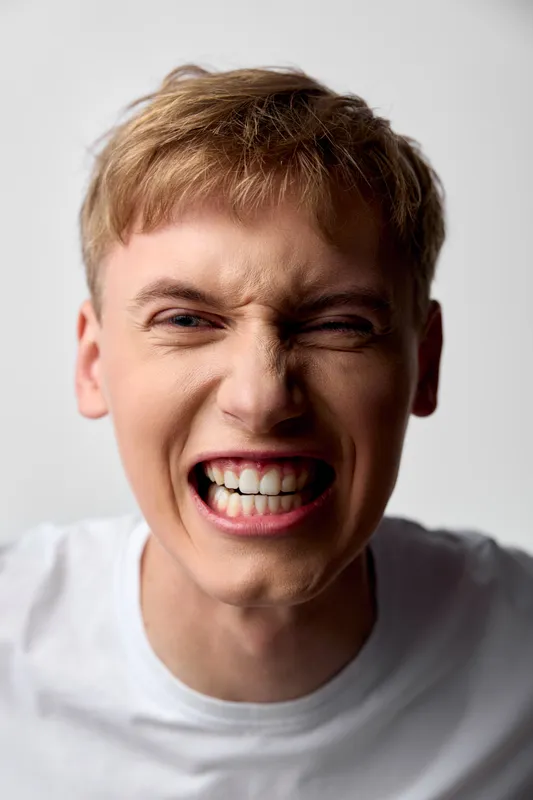 Close up of a tense man with clenched teeth and furious expression, conveying anger, frustration, and intense emotion suitable for stock imagery, impact, and dramatic reaction in creative campaigns