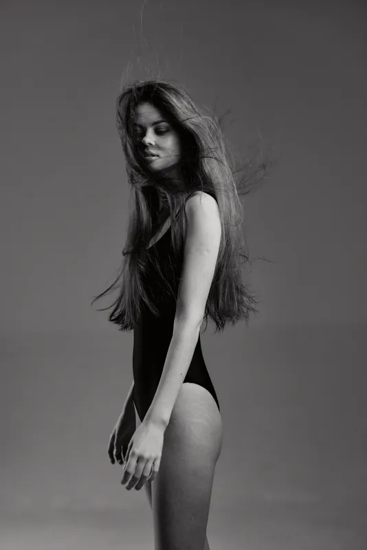 Black and white portrait of a slender young woman with long hair in a minimalist style, calm and elegant mood