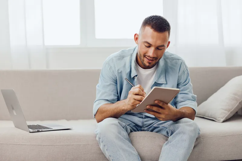 Thoughtful man engaged in creative work, balancing personal and professional life while finding peace during a digital detox in a cozy home setting.