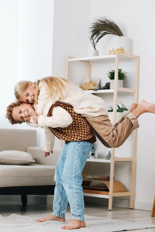 Authentic lifestyle moment capturing a playful scene in a cozy home, where two people share laughter and energy during a lighthearted school themed game, showcasing warmth and connection.