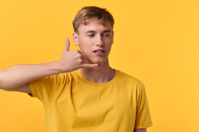 Hand, gesture, call, phone, yellow, shirt, man, casual, expression, greeting, communication, interaction, lifestyle, fashion, youth, vitality, modern, isolate, closeup, front, view, pose,