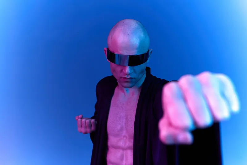 Futuristic man striking a dynamic pose in a striking blue ambiance, exuding confidence and strength, enhanced with vibrant lighting accents.