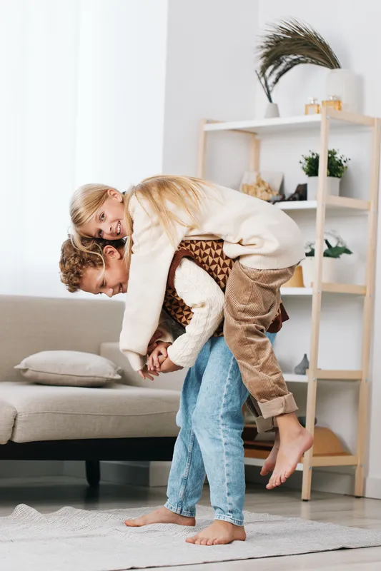 Authentic playful moment in a bright living room, where a family enjoys a gentle game, capturing real life school themed play and a warm casual lifestyle.