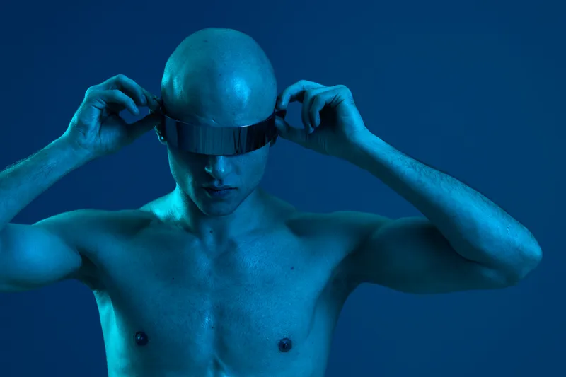 Futuristic man wearing sleek visor, showcasing a unique style and high-tech design. Captivating black and white tones create a striking visual contrast.