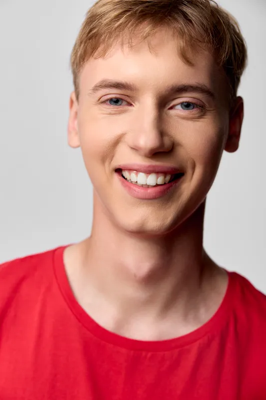 Cheerful headshot of a smiling man in a red shirt, bright casual lifestyle image for fashion, marketing and ecommerce use, suitable for branding, social posts and promo materials