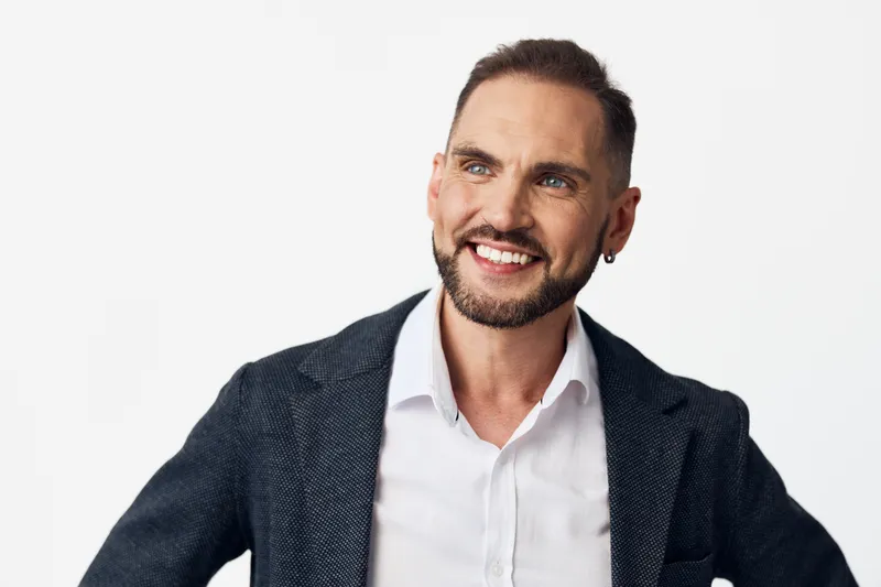 Portrait of a professional businessman on an isolated color background, exuding confidence, positivity, and focus through a warm, engaging smile.