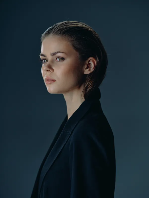 serious woman portrait with dark jacket and smooth hairstyle against dark background