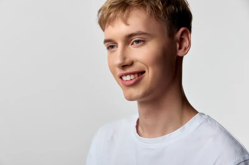Smiling man in a white t shirt in a clean studio, casual and approachable, friendly expression suitable for lifestyle, wellness and positive branding visuals