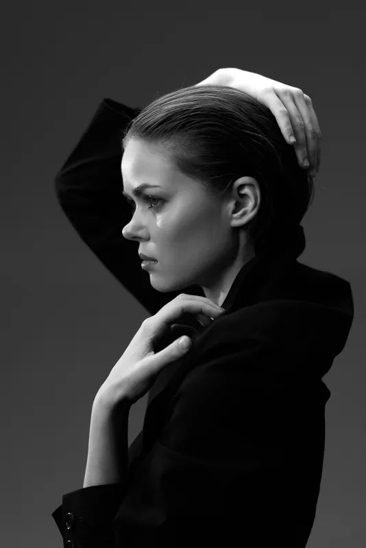 Sad woman in black and white with tear on her cheek, expressing deep emotion and reflection