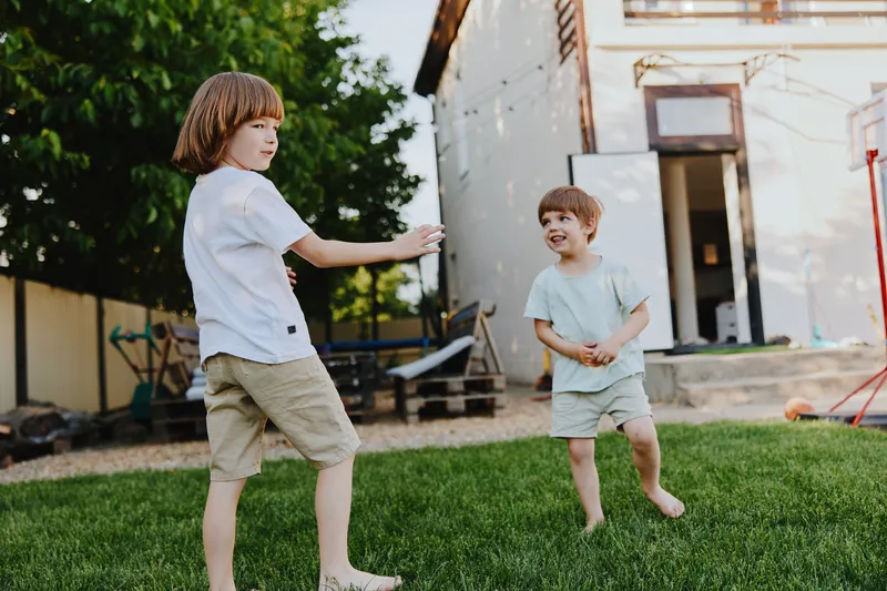 Happy children playing joyfully in the garden, enjoying a sunny day outdoors, capturing the essence of childhood and friendship.