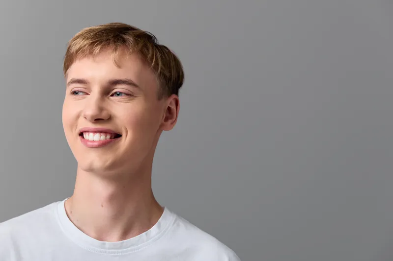 Smiling man in a casual white t shirt against a neutral backdrop, conveying confidence, warmth and approachable mood for lifestyle use and everyday positivity in stock photography