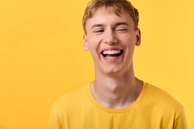 Happy smiling man in a bright yellow background wearing a casual shirt, radiating joyful energy, warmth, and positive mood suitable for lifestyle, wellness, and upbeat campaigns.