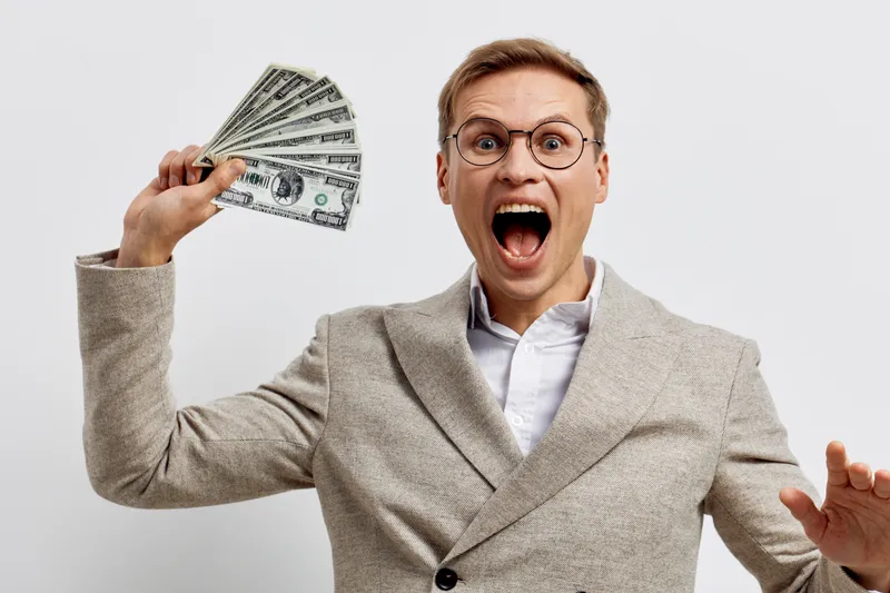 Wide shot happy cheerful man holding fan of dollar bills argue excitedly in beige sweater wear glasses studio isolated on white background People lifestyle concept