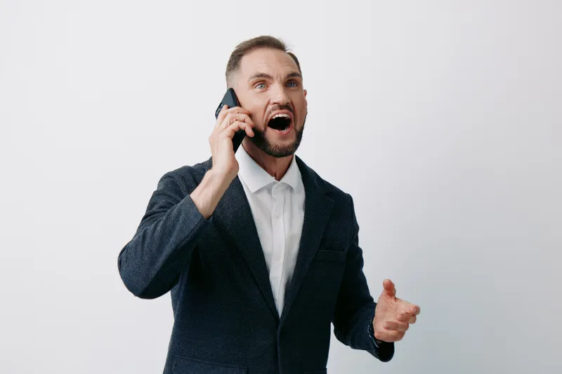 A professional man on a business call against an isolated colored background, showing strong emotion and enthusiasm, with confident focus and dynamic energy.