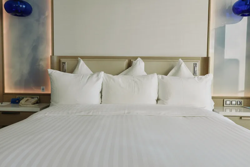 Bed pillow bedding hotel white room linen comfort, clean and fresh bedding setup with plush pillows in a serene modern hotel room for restful sleep and calm ambiance.