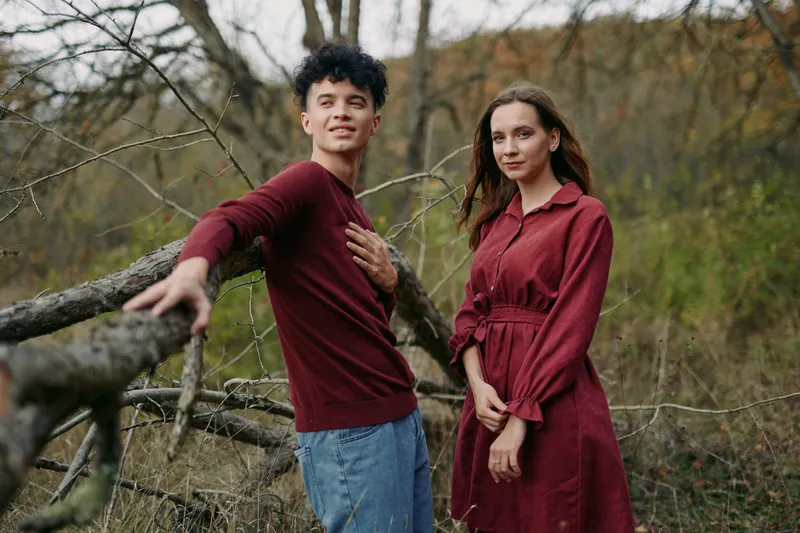 A candid scene with two individuals in a natural setting, conveying genuine connection, trust, and authentic emotion amid a quiet woodland backdrop.