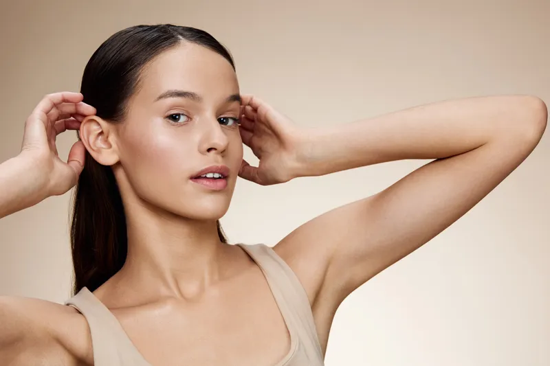 Young model with natural makeup showcasing healthy skin, elegant pose, and soft lighting against a neutral background KEY model, healthy skin, natural makeup, elegant pose, neutral background, soft