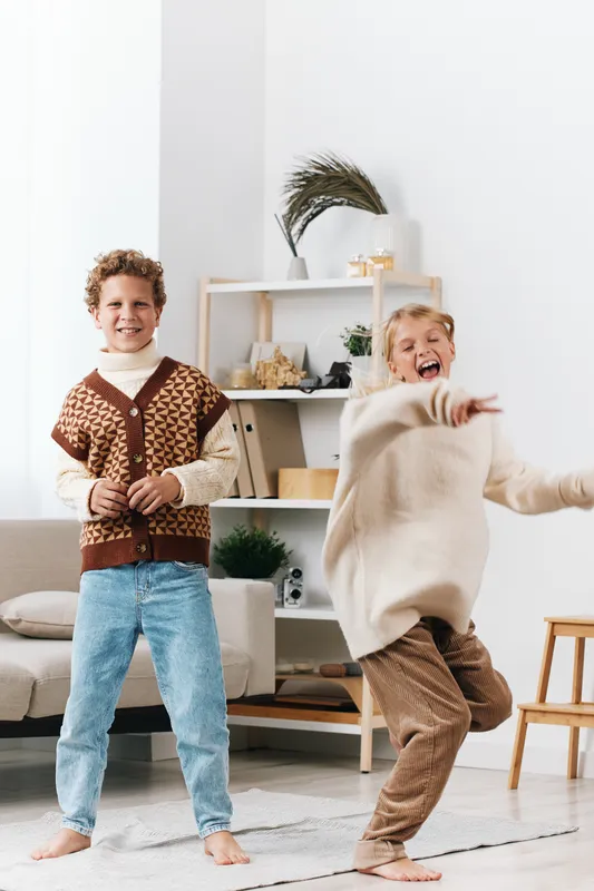 Authentic scene of children at play in a cozy living room, school themed and lifestyle oriented, candid moment showing imagination, energy, and everyday learning.