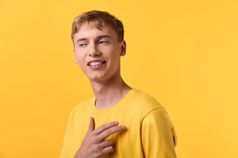 Yellow studio scene with a smiling man in a casual shirt, posed confidently against a bright background. Clean, contemporary fashion mood for lifestyle, advertising, and branding campaigns