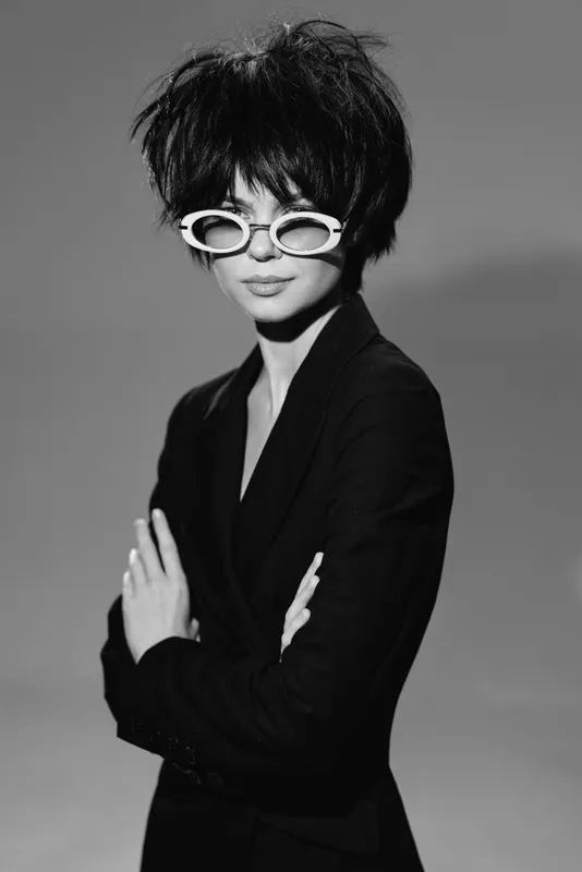 stylish woman wearing white sunglasses in black and white fashion portrait with confident pose