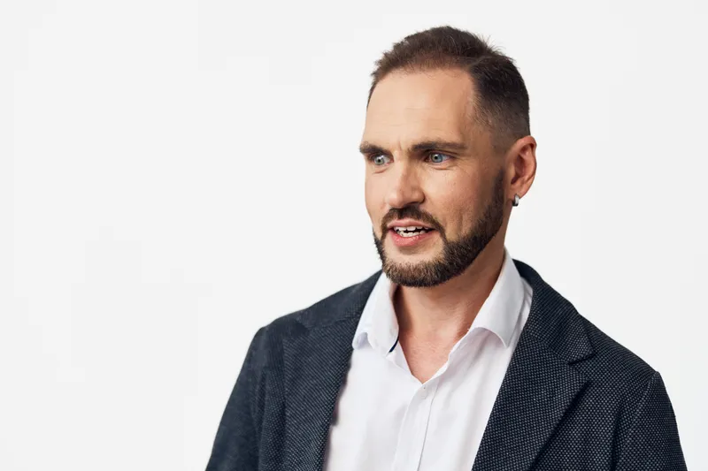 A professional man in a blazer and white shirt stands against an isolated white background, projecting confident and thoughtful emotion ideal for business scenes.