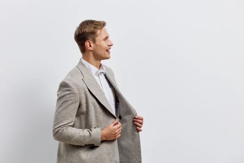 Young caucasian smiling man in gray checkered blazer look side pose with happy expression isolated on white background work in digital nomad lifestyle concept